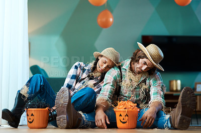 Buy stock photo Shot of a young couple in halloween costumes sleeping at home