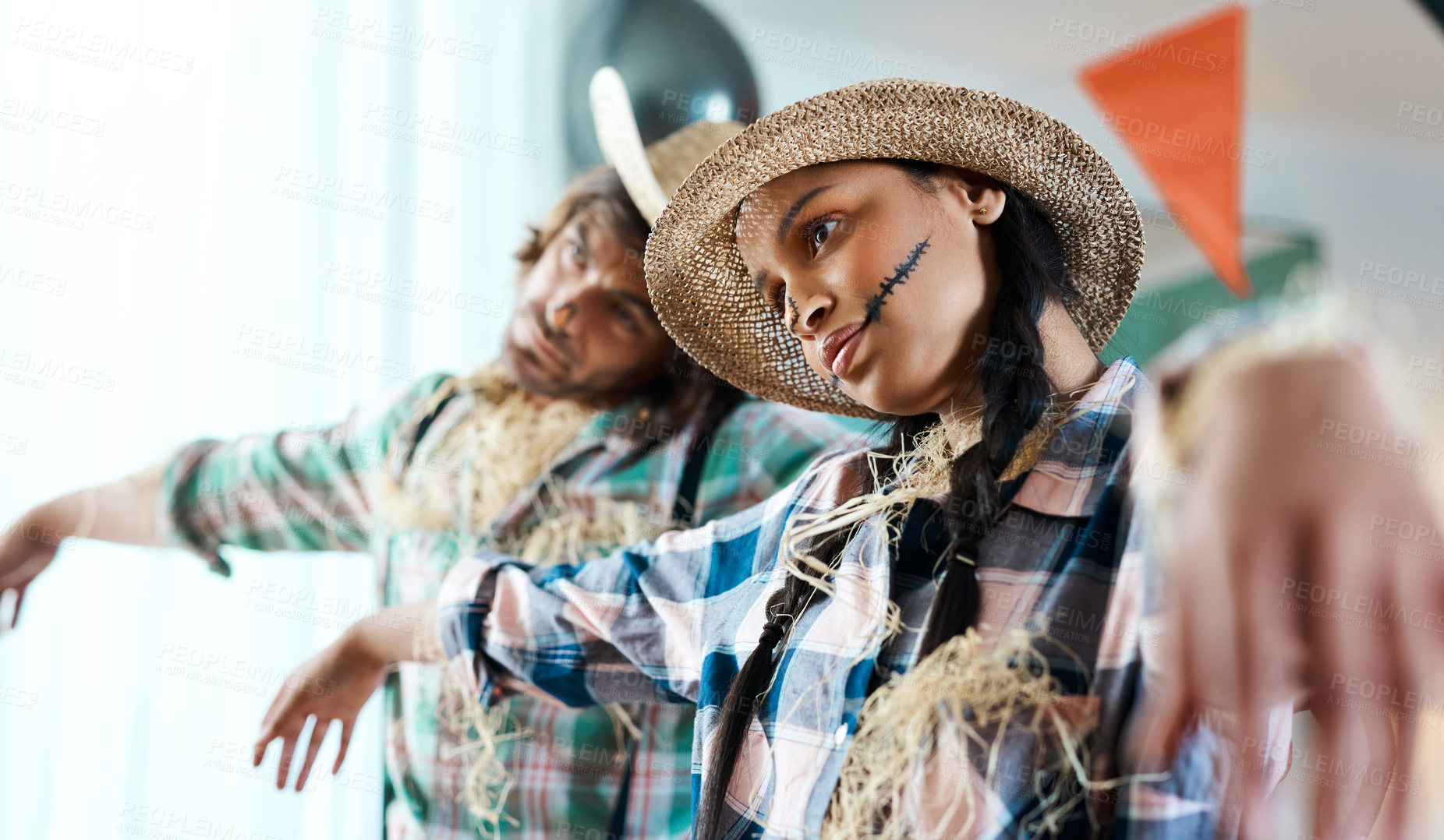 Buy stock photo Shot of a young couple dressed in halloween costumes being being playful at home