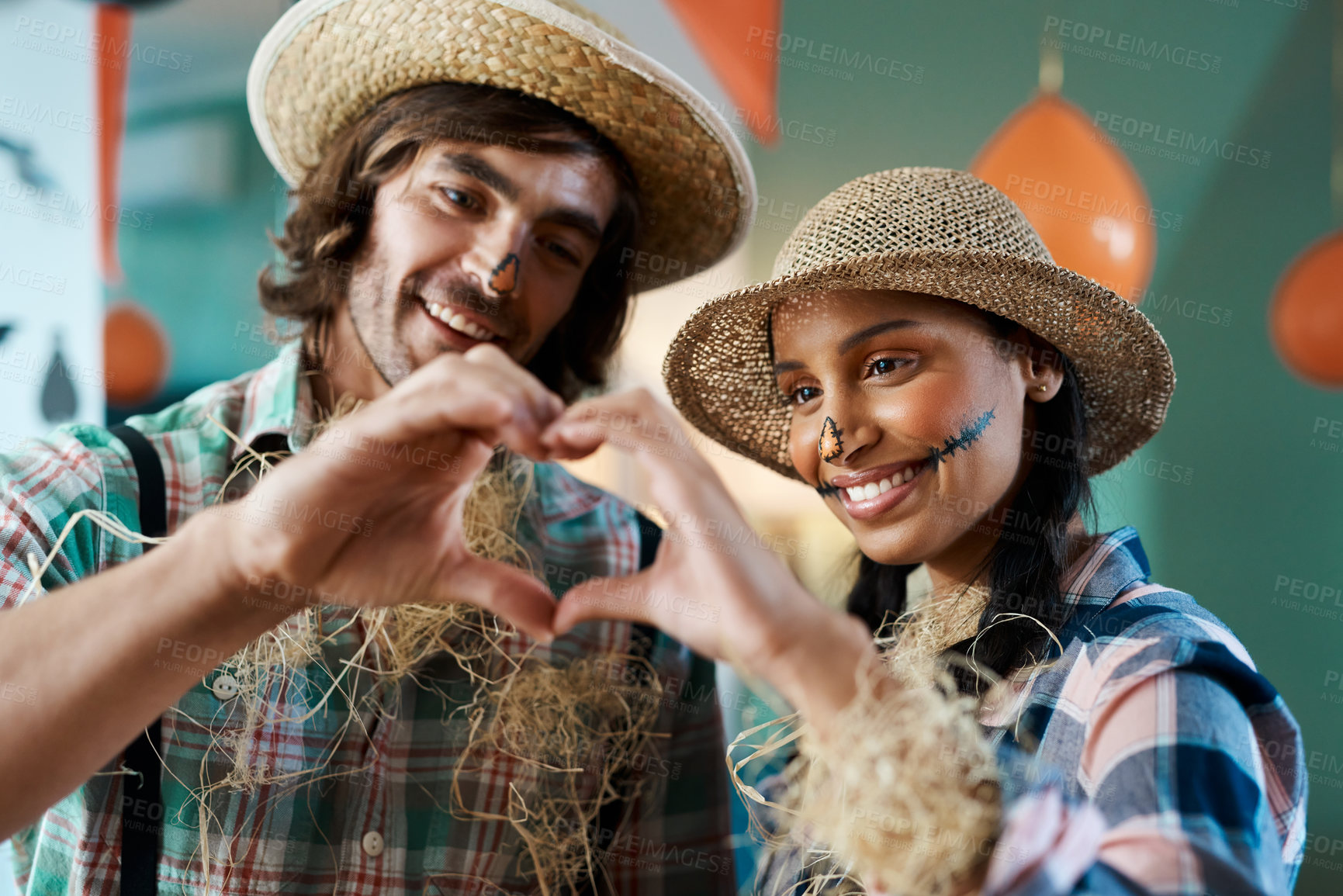 Buy stock photo Shot of a young couple making a heart gesture with their hands at home