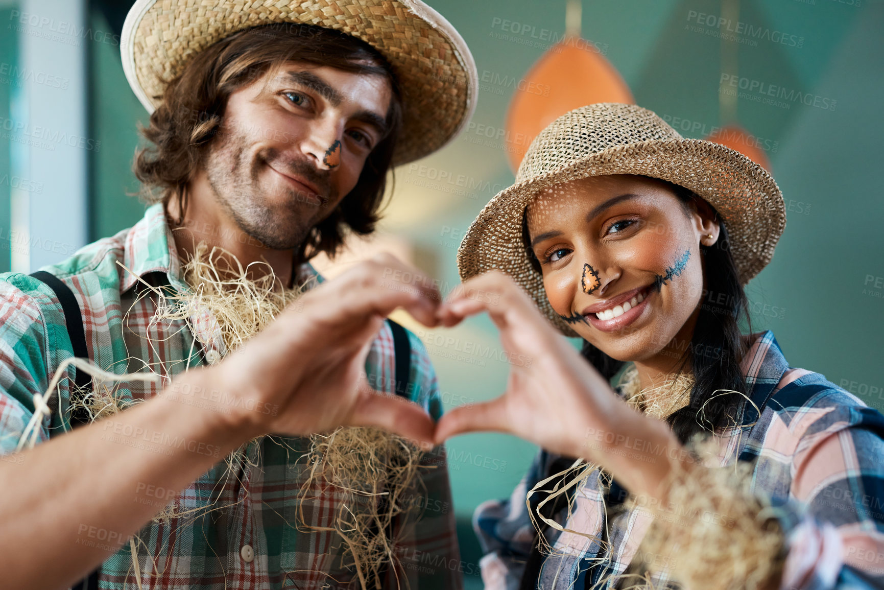 Buy stock photo Shot of a young couple making a heart gesture with their hands at home