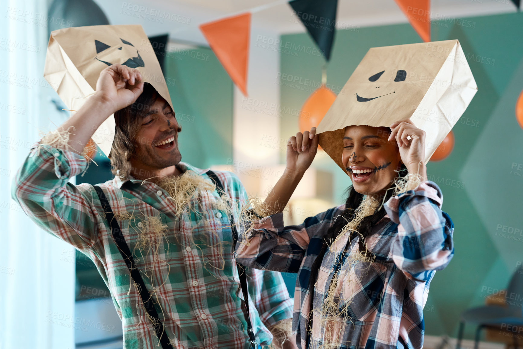 Buy stock photo Shot of a young couple with paper bags over their heads at home