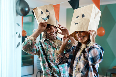 Buy stock photo Shot of a young couple with paper bags over their heads at home