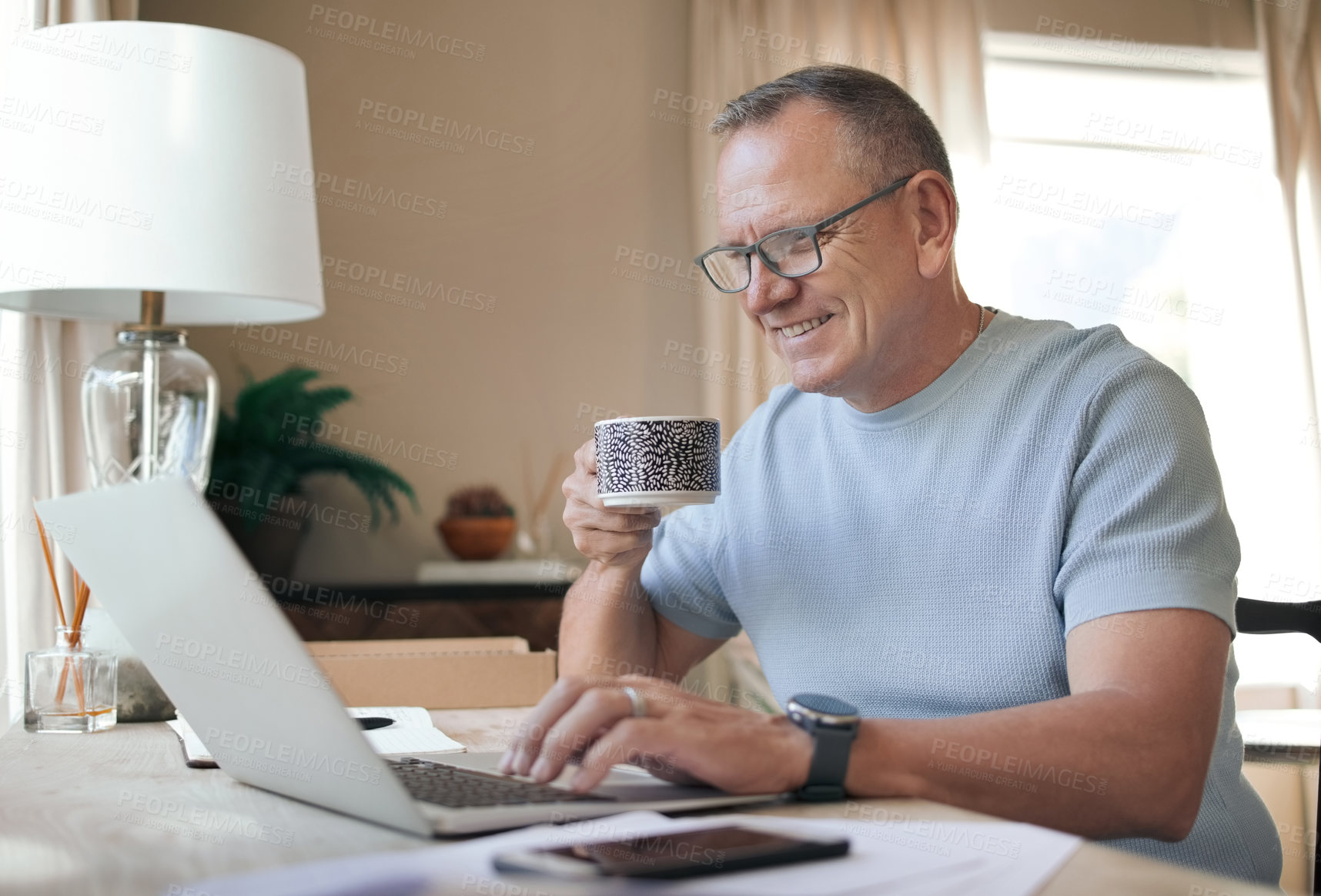 Buy stock photo Shot of a mature man drinking a cup of coffee while working