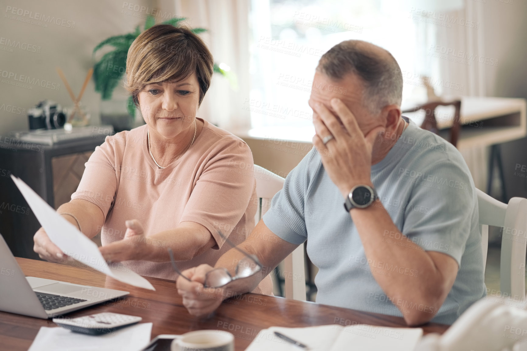 Buy stock photo Shot of a mature husband and wife going over their finances together