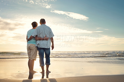 Buy stock photo Rearview shot of a couple admiring the view while at the beach