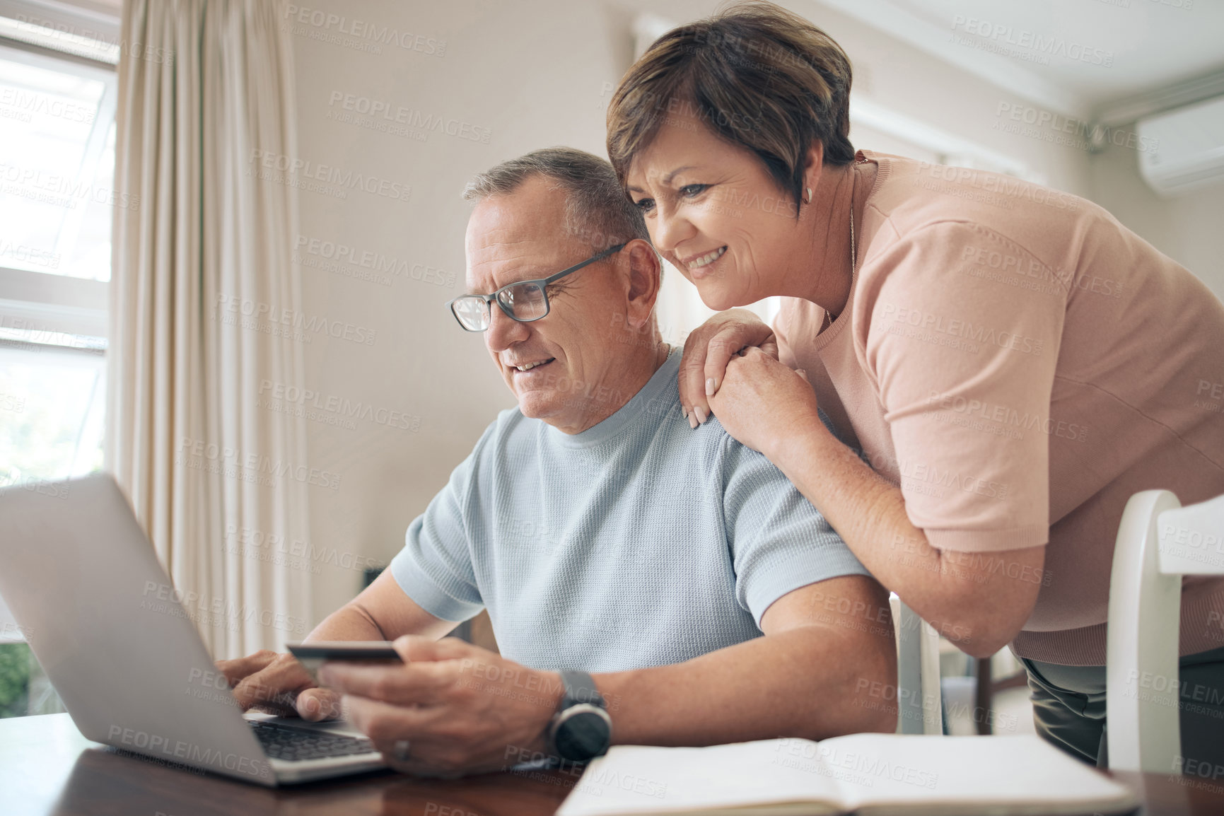 Buy stock photo Shot of a mature man using his bank card to make online payments