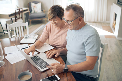 Buy stock photo Shot of a mature couple using their bank card to digitally pay their bills