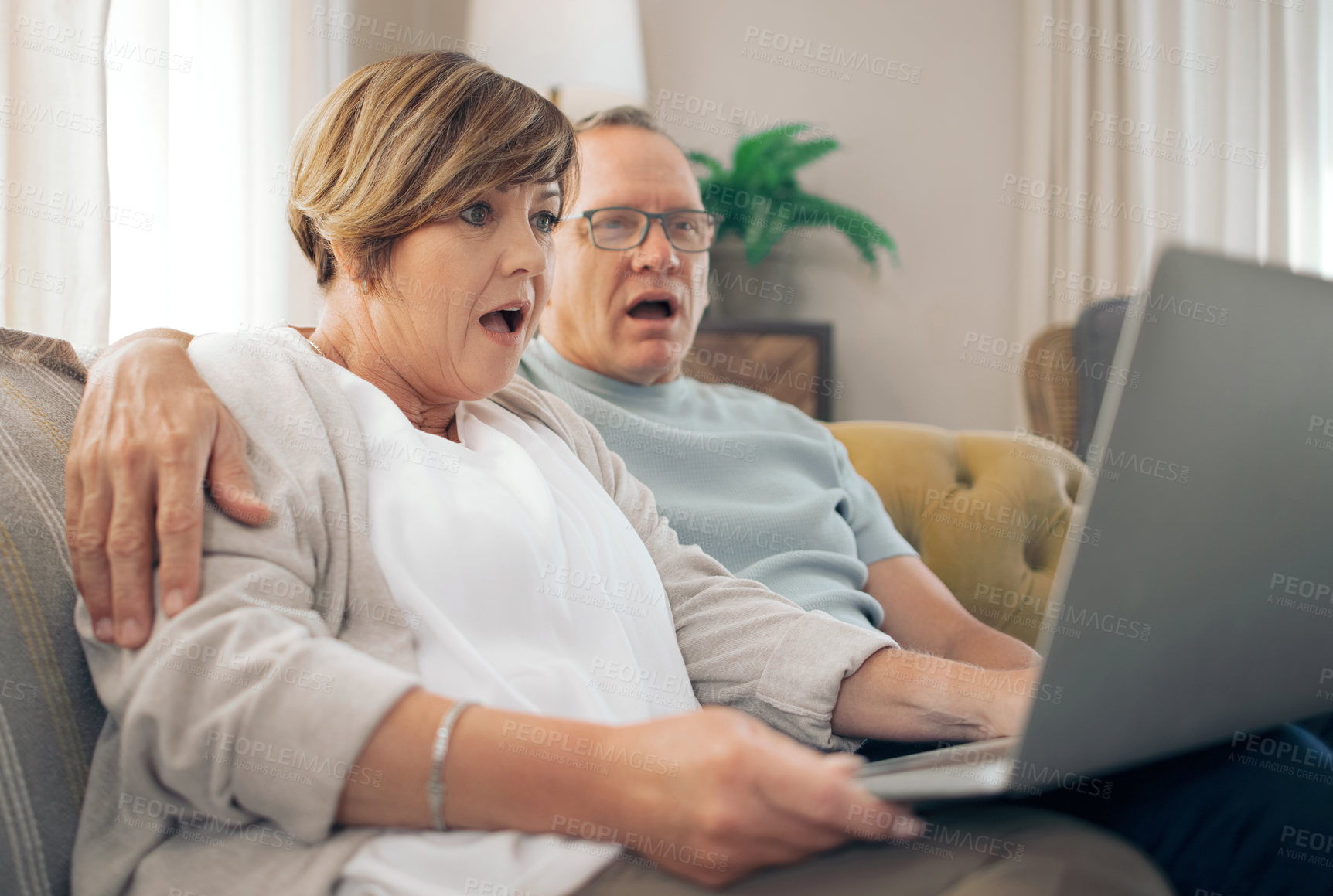Buy stock photo Shot of a mature couple using their laptop to make a video call