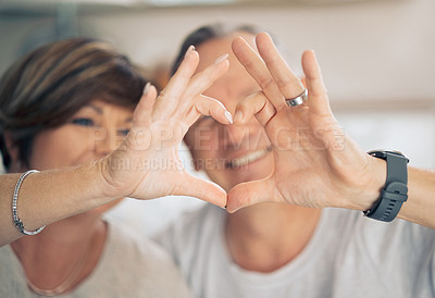 Buy stock photo Shot of a mature couple forming a heart shape with their hands