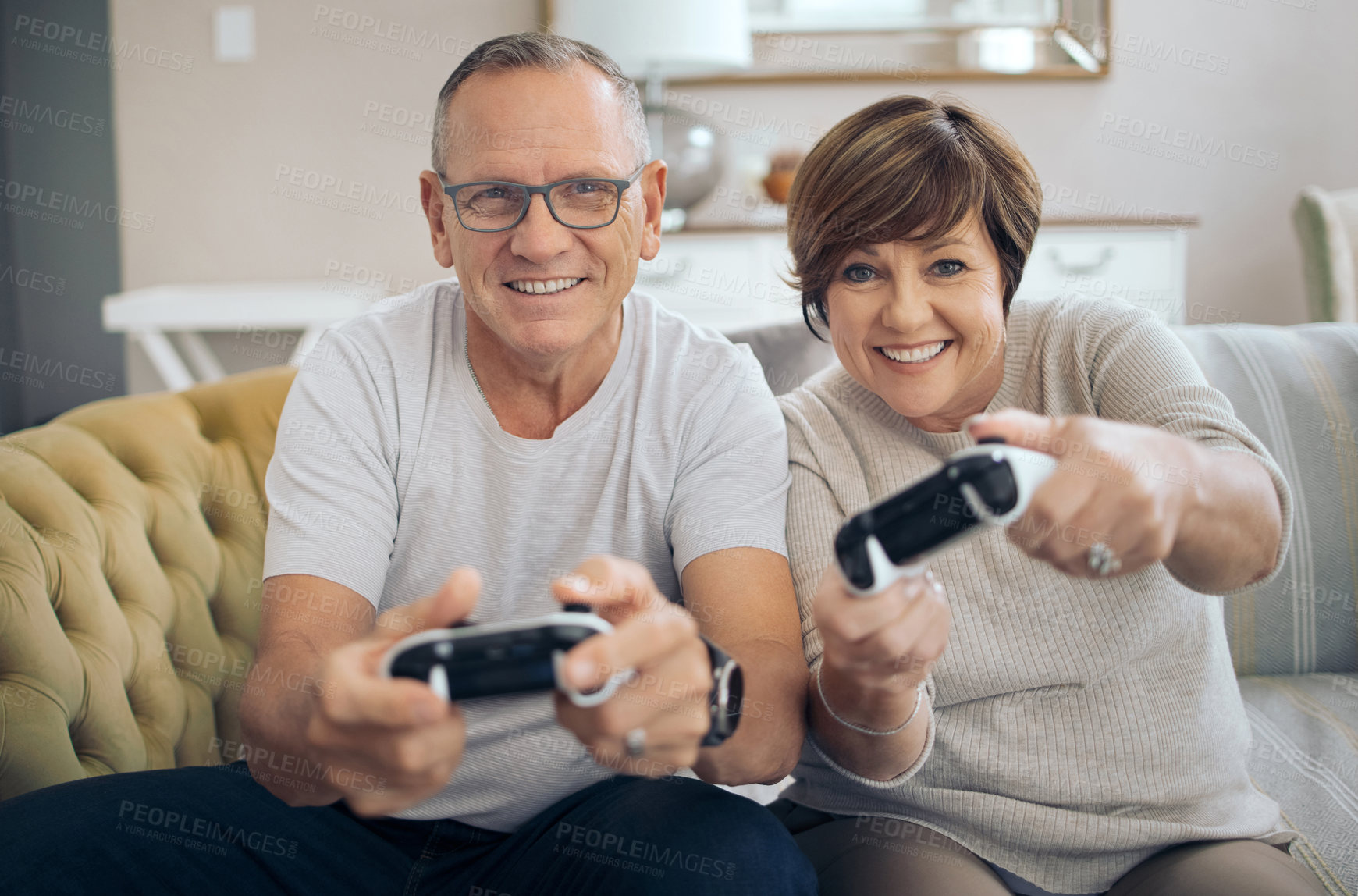 Buy stock photo Shot of a mature husband and wife playing video games together