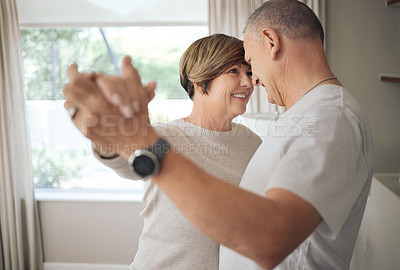 Buy stock photo Shot of a mature couple slow dancing in their lounge