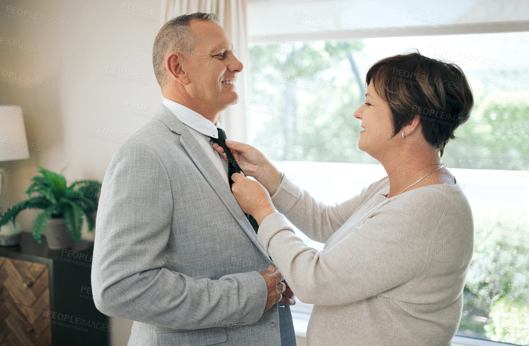 Buy stock photo Shot of a mature woman helping her husband fix his tie