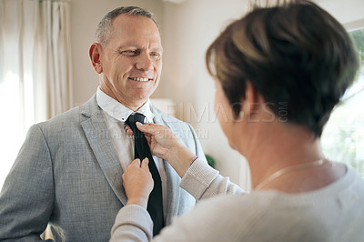 Buy stock photo Shot of a mature woman helping her husband fix his tie