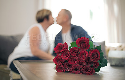 Buy stock photo Shot of a mature wife kissing her husband in thanks for the roses