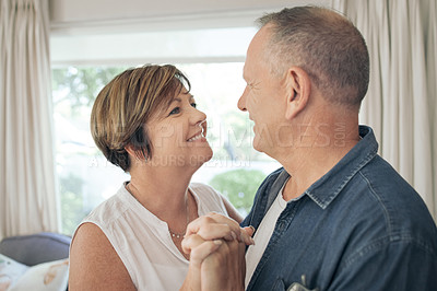 Buy stock photo Shot of a mature couple slow dancing in their lounge