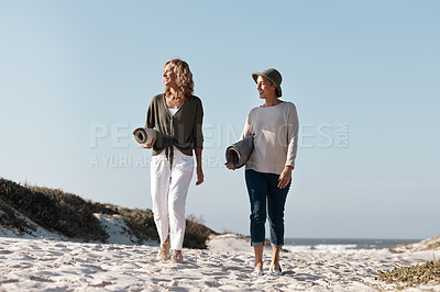 Buy stock photo Full length shot of two attractive mature woman walking with their on the beach