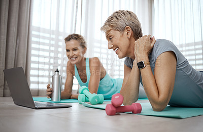 Buy stock photo Shot of two mature women browsing the internet for new workout ideas while exercising at home