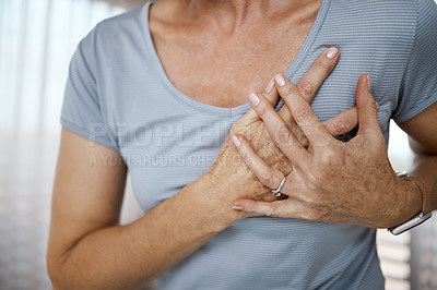 Buy stock photo Cropped closeup of an unrecognizable woman experiencing cardiac discomfort at home