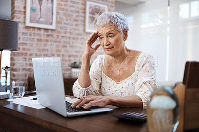 Buy stock photo Shot of a senior woman looking stressed while using a laptop at home