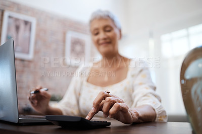 Buy stock photo Shot of a senior woman using a laptop and calculator while going through finances at home