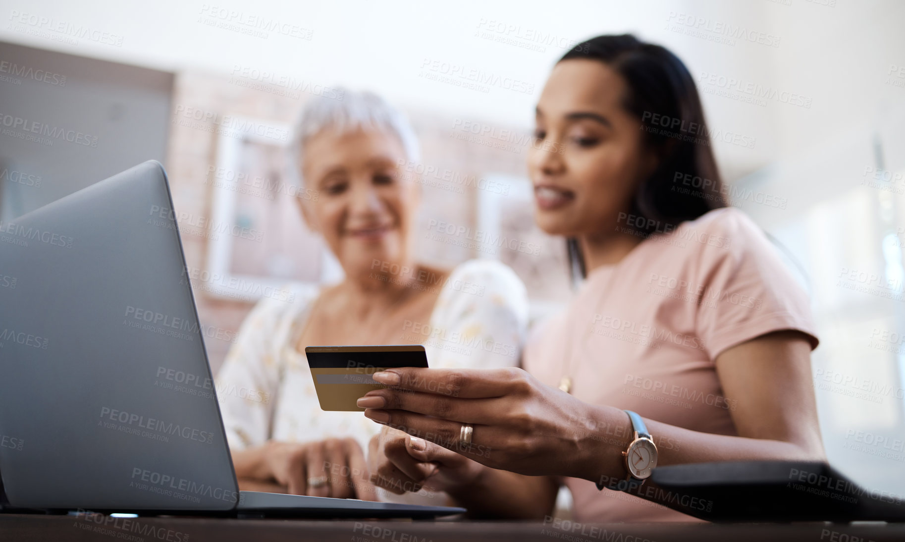 Buy stock photo Shot of a senior woman using a laptop and credit card with her daughter at home