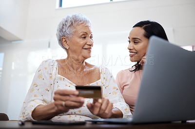 Buy stock photo Shot of a senior woman using a laptop and credit card with her daughter at home