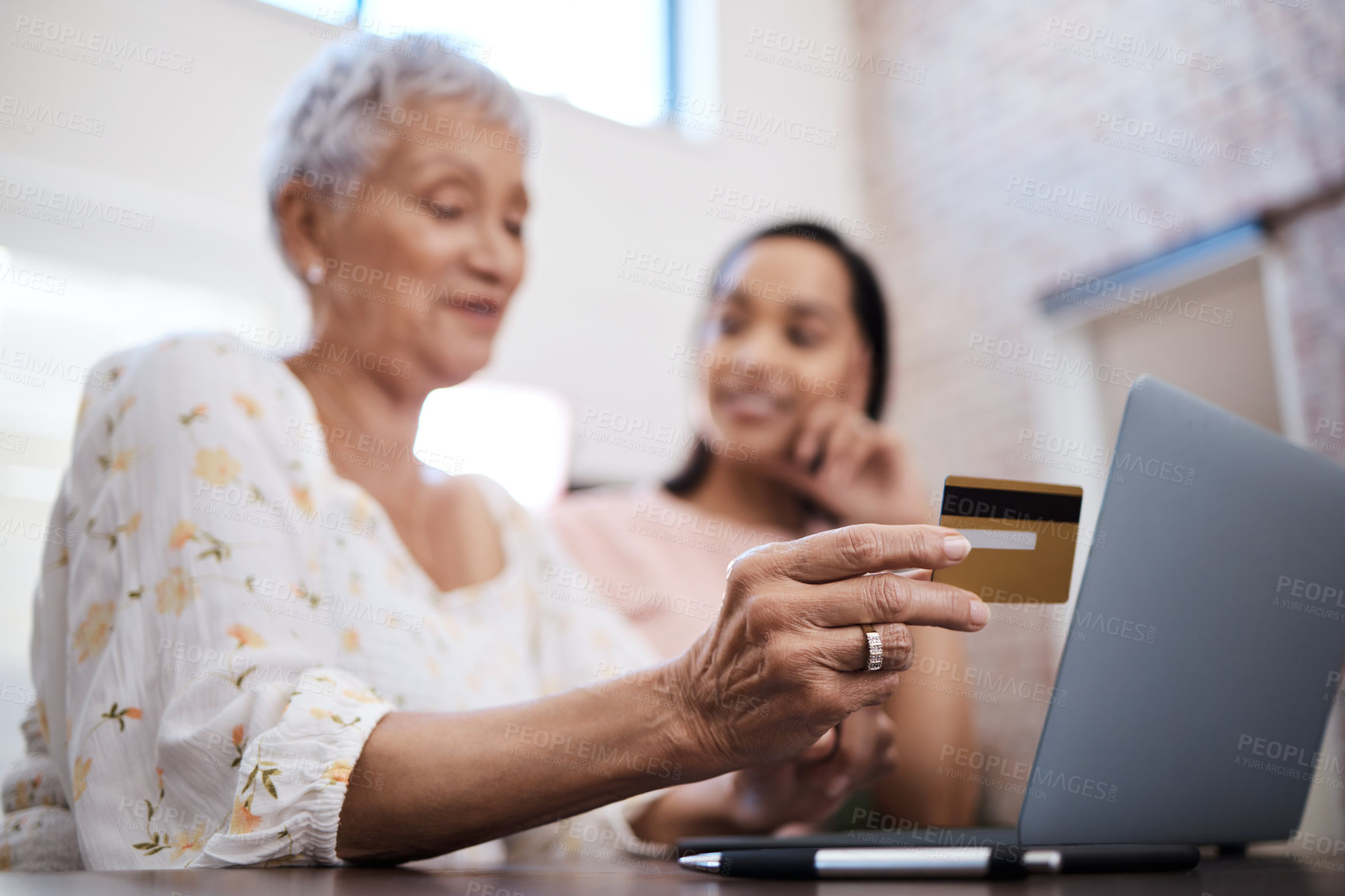 Buy stock photo Shot of a senior woman using a laptop and credit card with her daughter at home