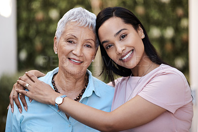 Buy stock photo Shot of a senior woman spending time with her daughter in their garden at home