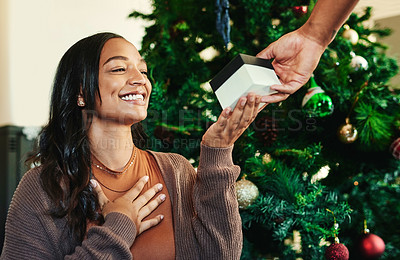Buy stock photo Christmas, hand with gift and woman with smile, couple and present exchange, surprise and happy to celebrate holiday. Christmas tree, love and care with box, celebration and festive tradition.