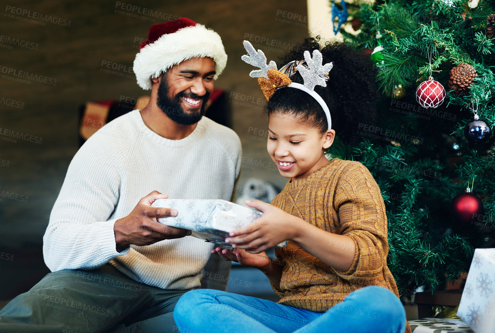 Buy stock photo Christmas, children and gift with a father and daughter in celebration of the festive season together. Kids, happy and love with a man giving a girl a present in the living room of their home