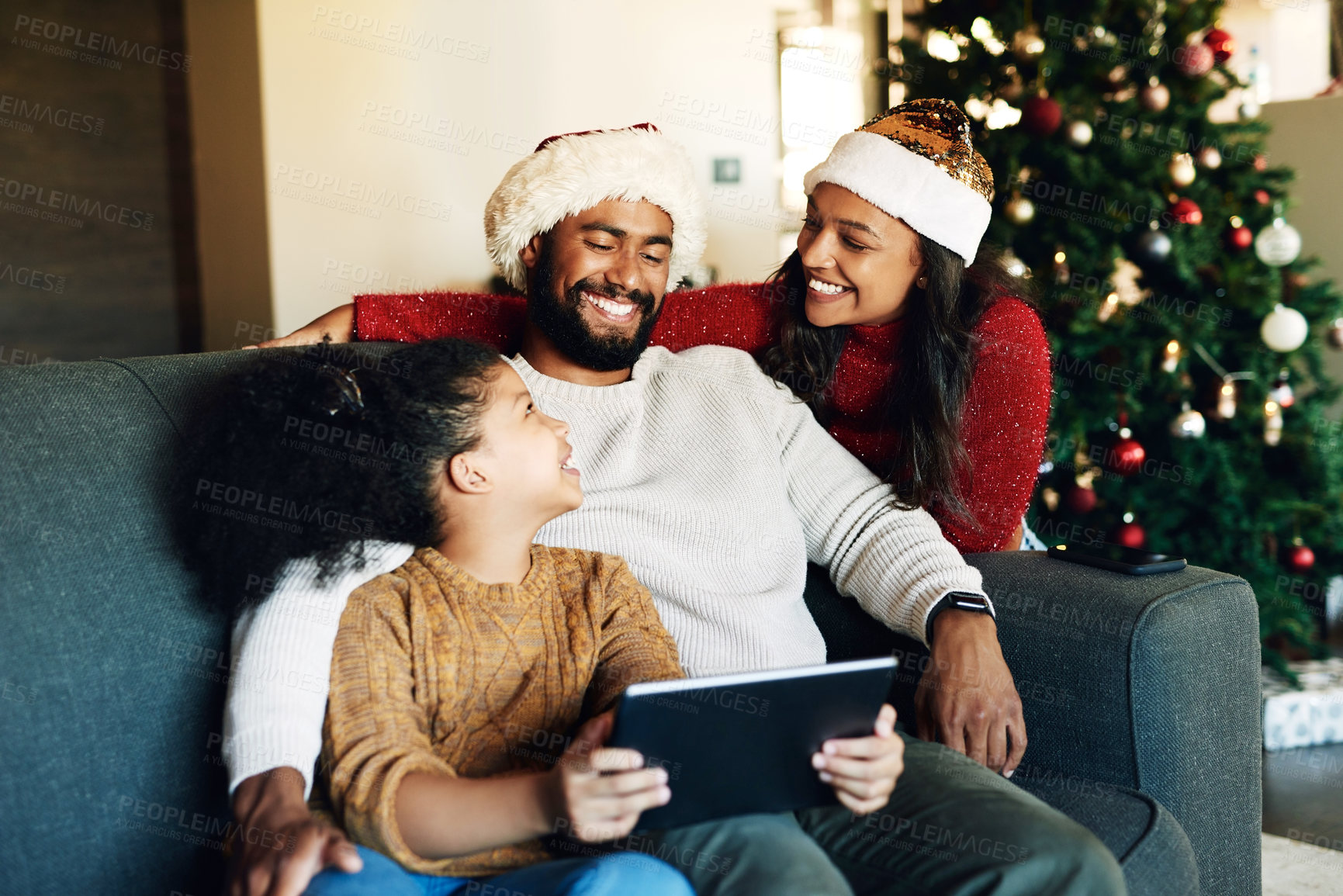 Buy stock photo Christmas, family and tablet on sofa in home streaming movie or internet browsing. Xmas, love and girl, father and mother with digital touchscreen bonding, caring and enjoying holiday time together.