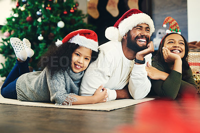 Buy stock photo Happy family, mother and father with child for Christmas celebration while relaxing on living room floor at home. Mom, smile and young girl hugging her laughing dad enjoying quality time for bonding
