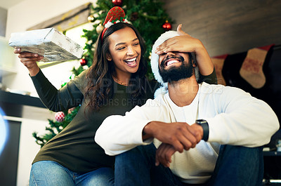 Buy stock photo Couple, bonding and surprise christmas gift in house or home living room for celebration, festive holiday or Portugal vacation. Smile, happy or xmas man and woman with present box in love or support