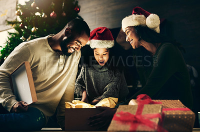 Buy stock photo Happy family, bonding or surprise christmas gift in night house or home living room in celebration event, festive holiday or vacation. Smile, happy or shocked child, xmas mother or father and present