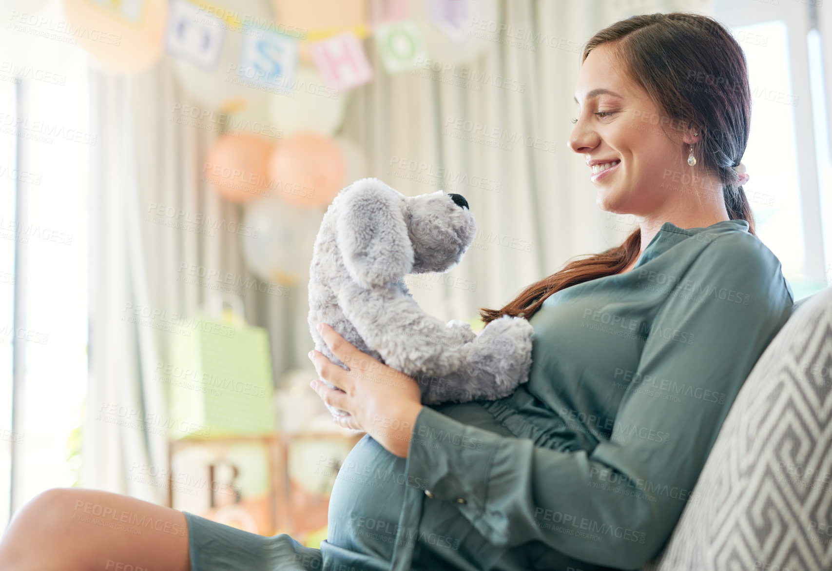 Buy stock photo Shot of a young mother to be holding a soft toy meant for her child