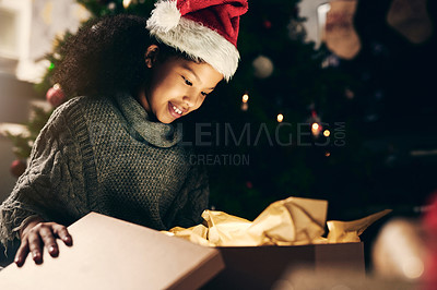 Buy stock photo Christmas, gift and girl opening box at night in home alone on holiday. Xmas time, happy and excited child or kid looking at shiny presents or gifts, smiling and enjoying December holidays in house