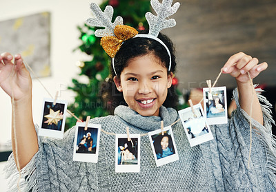 Buy stock photo Christmas, celebration and girl with polaroid for decoration, happy and show photos in the house. Smile, excited and portrait of a child with pictures to decorate the home for a festive xmas