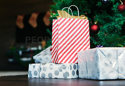 Buy stock photo Christmas, gift and tree on floor in home for surprise, giving and celebration in holiday season. Bag, box and present on flooring by christmas tree for happiness, tradition and happy spirit in house