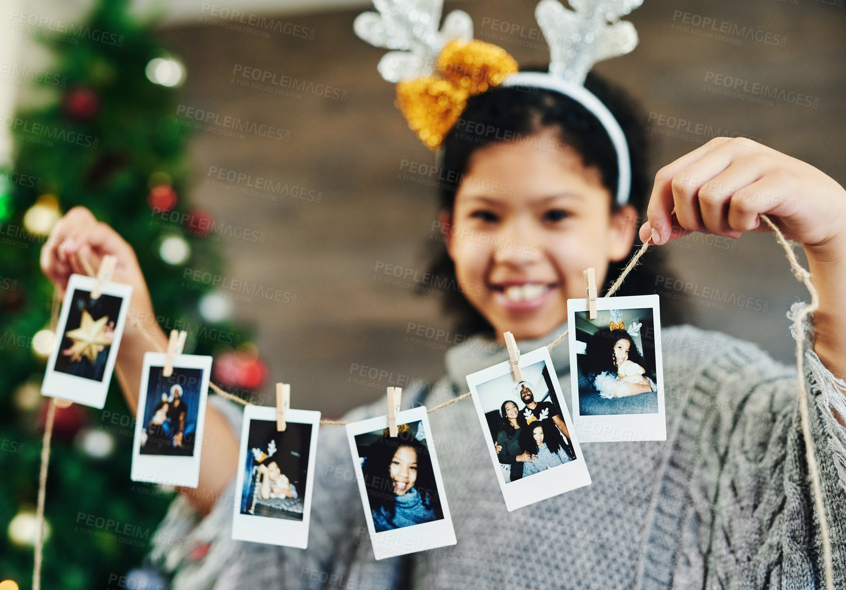 Buy stock photo Girl portrait, polaroid and christmas celebration, happy smile and memories, photograph and decoration in home. Child, picture and string for xmas, celebrate and festive holiday, happiness and kid