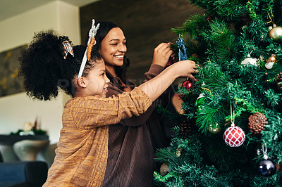 Buy stock photo Mother, girl and bonding with christmas tree decoration in family home or house for celebration event, festive holiday or vacation. Smile, happy or xmas woman and child hanging lights, balls or decor