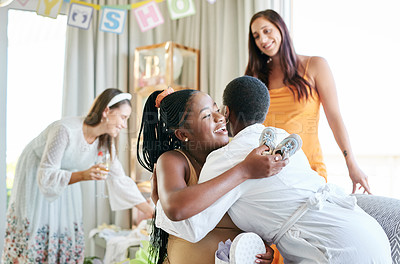 Buy stock photo Shot of a young mother to be hugging her friend for a gift given at her baby shower