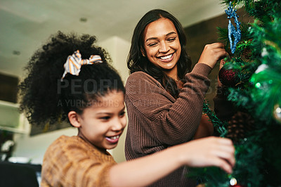 Buy stock photo Christmas tree decoration, family and mother with girl helping in living room. Black family, love and care of happy child bonding with mama, decorating tree and getting ready for xmas party in house.