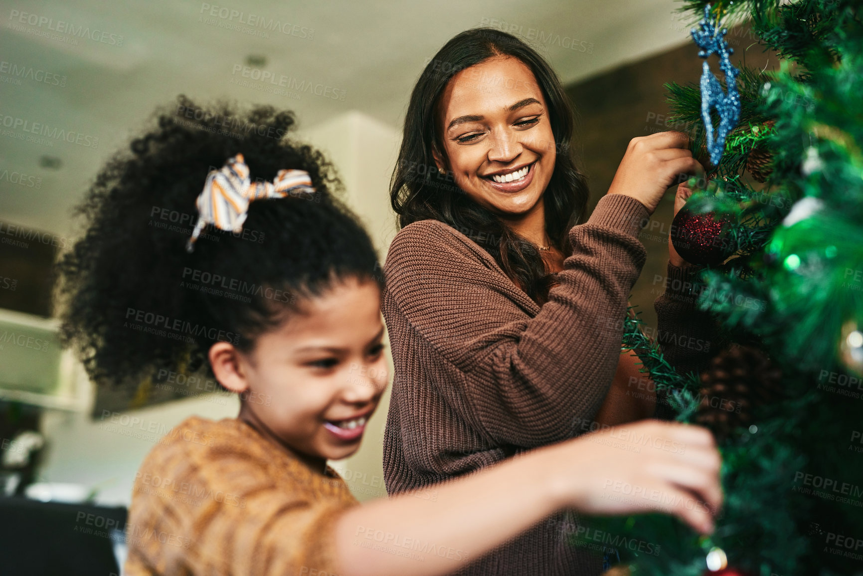 Buy stock photo Christmas tree decoration, family and mother with girl helping in living room. Black family, love and care of happy child bonding with mama, decorating tree and getting ready for xmas party in house.