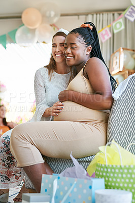 Buy stock photo Shot of two female friends hugging during a baby shower