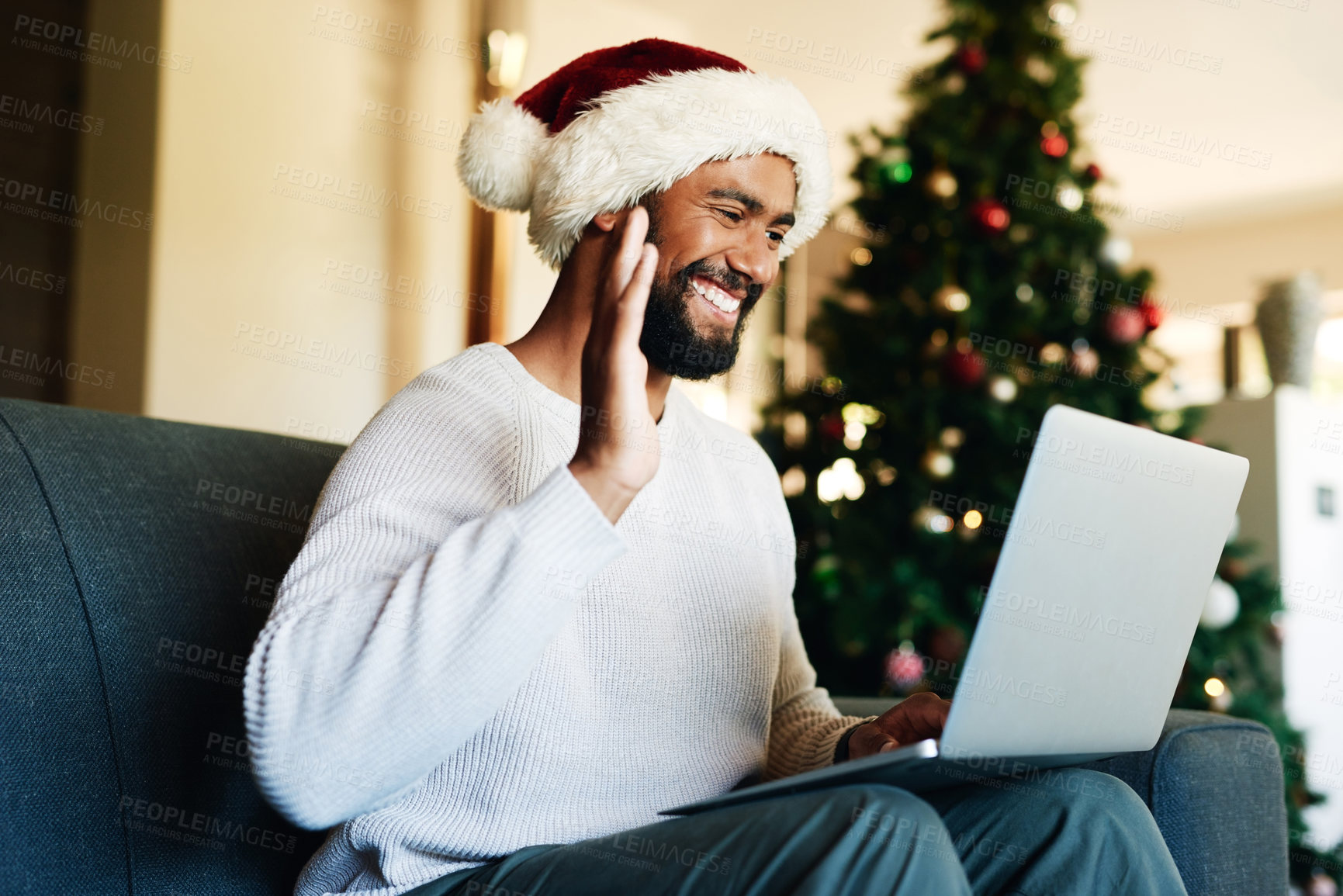 Buy stock photo Man, laptop and video call, wave and christmas celebration in home, virtual conversation or communication in home. Young male, happy smile and hand gesture with video conference , internet or webinar