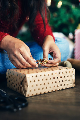 Buy stock photo Hand, christmas and gift with a woman preparing surprise for festive season while sitting on the floor. Hands, closeup and wrapping xmas present with a bow to get ready for a traditional december 