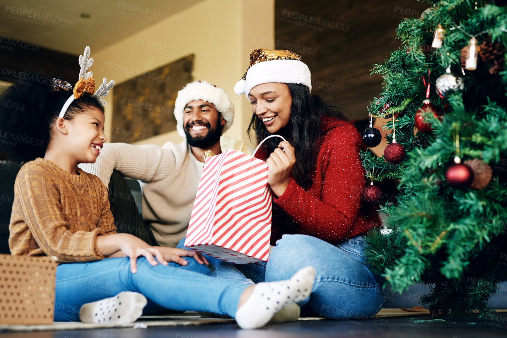 Buy stock photo Christmas, love and family opening gifts in home, having fun and bonding on holiday. Xmas spirit, care and happy father, mother and girl exchange presents in living room and enjoying quality time.