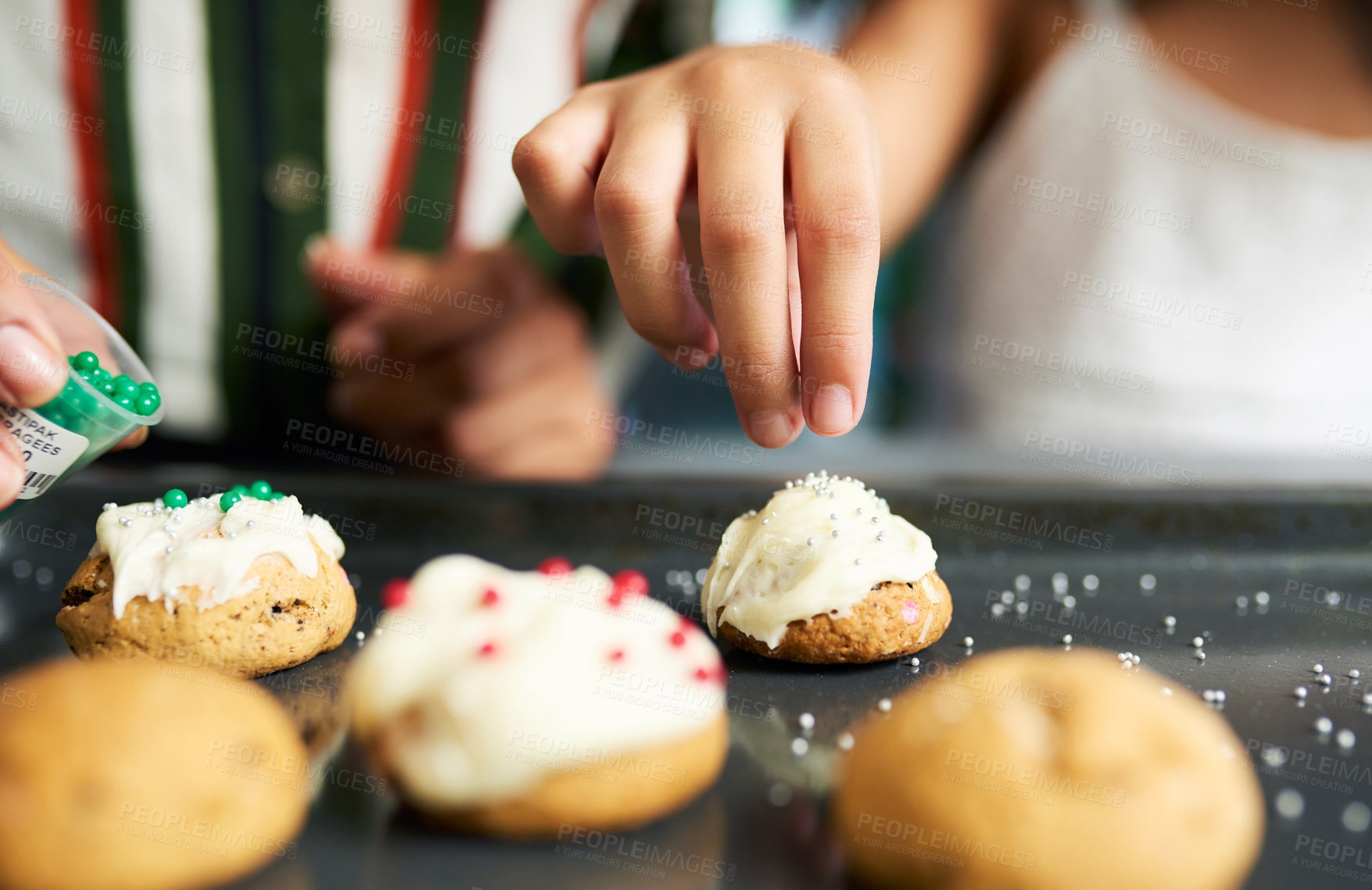 Buy stock photo Girl hands, decorating cookies and closeup with sparkles, cream or candy in kitchen for learning. Family home, child cooking and christmas biscuits on table for domestic skills, education or teaching