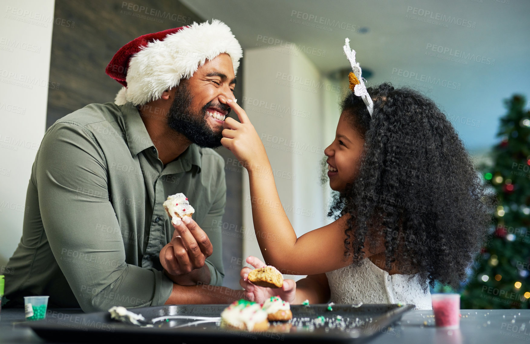 Buy stock photo Christmas, father and kid with cookie, food fight and playful, celebrate and holiday fun at home. Happy family, man with girl and love, baker dessert and celebration, happiness and xmas at home.