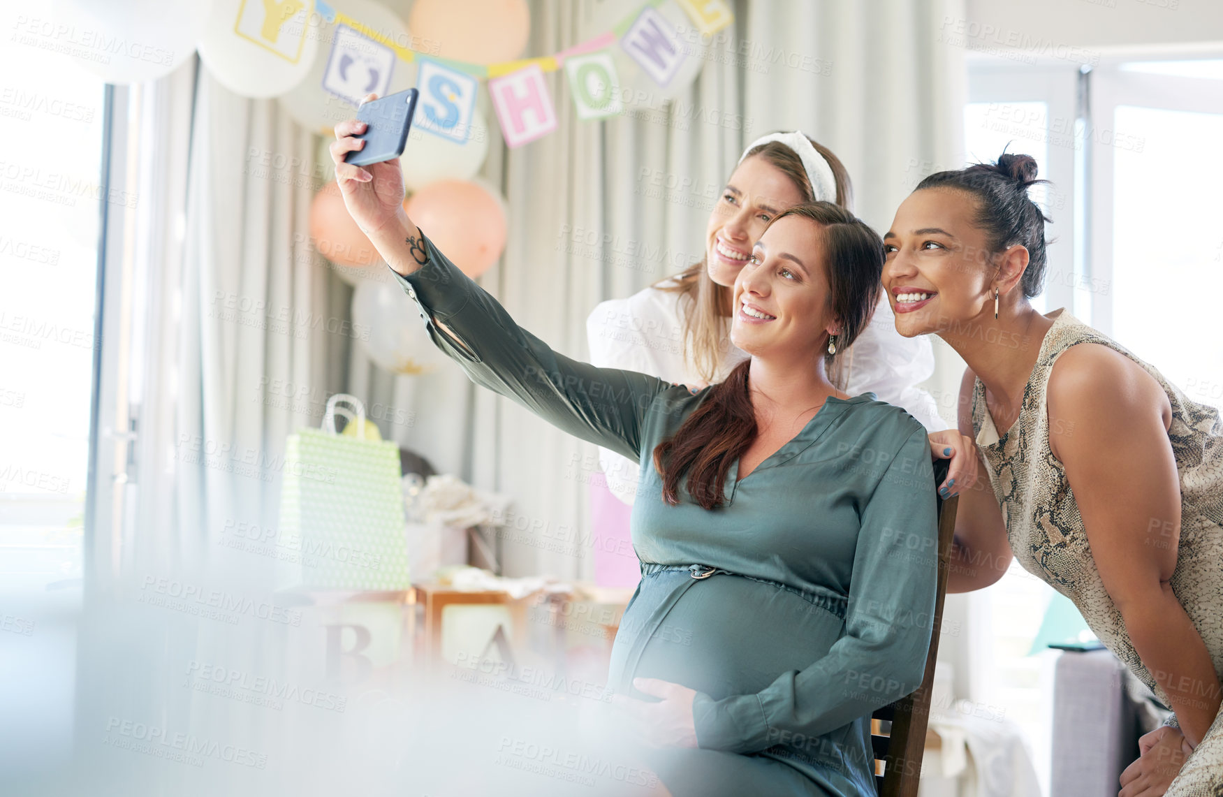 Buy stock photo Shot of a group of female friends taking selfies at a baby shower